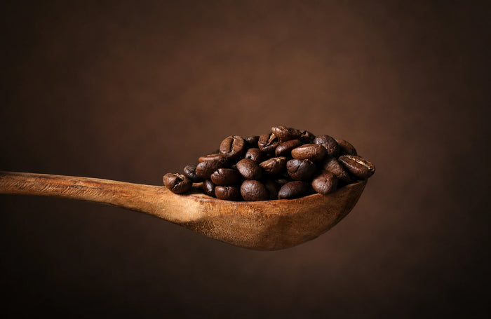 Still-Life-Aufnahme von frisch gerösteten Kaffeebohnen auf einem Holzlöffel. Detailreiche Produktfotografie für Espresso, Kaffee und italienische Kaffeekultur.