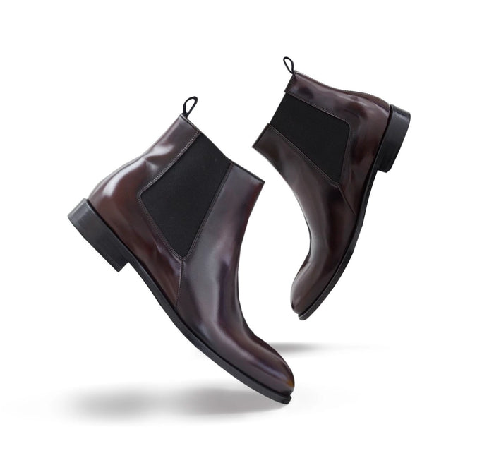 Stilvolle Studioaufnahme handgefertigter Herren-Chelsea-Boots aus hochwertigem braunem Leder. Schwebende Produktfotografie mit Fokus auf Qualität, Eleganz und traditionelle Handwerkskunst.
